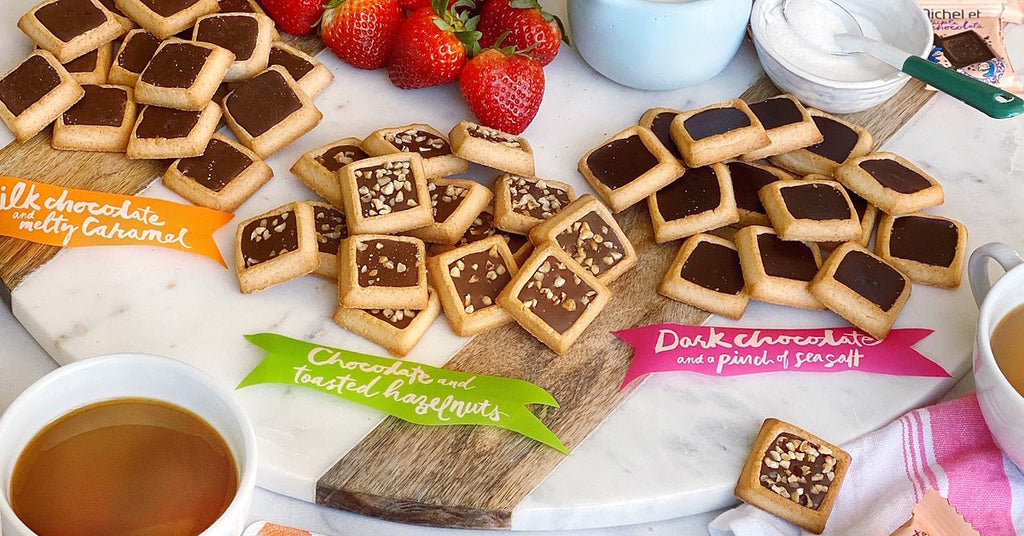 A Marble and Wood Cookie Platter Decorated With Cookies, Dips, and Strawberries
